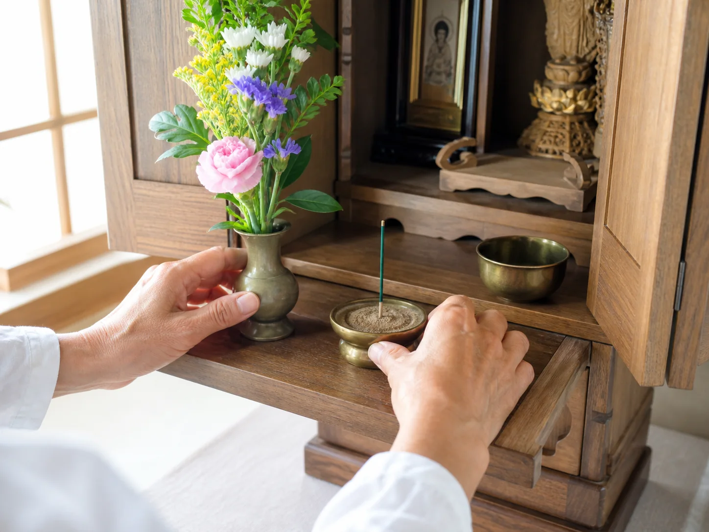 明るい部屋で花立と香炉を整える手元