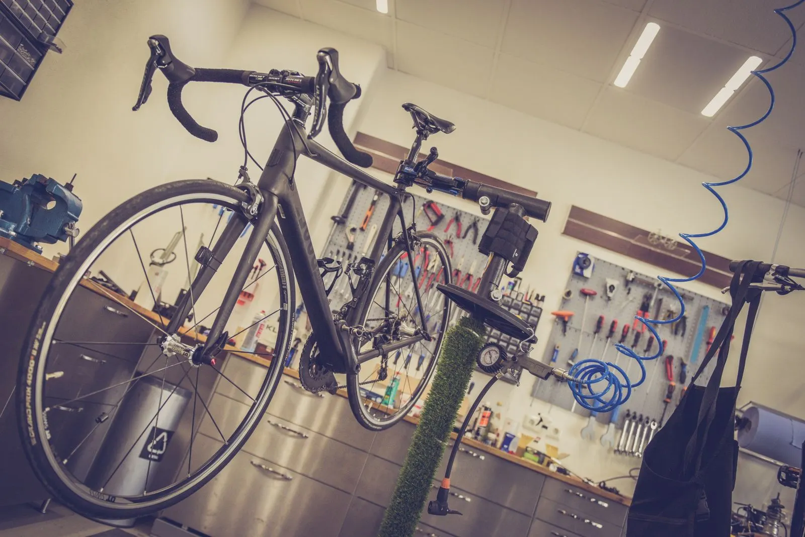 整備台に載せたスポーツ自転車と工具の壁