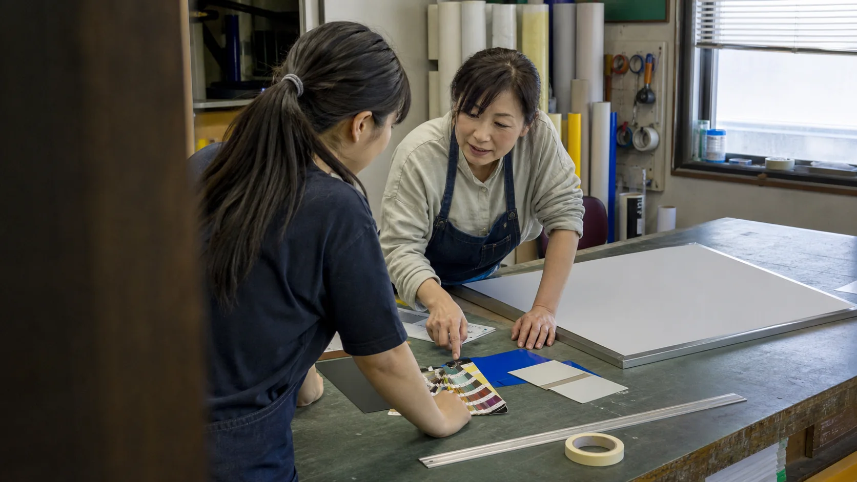 看板の色とレイアウトを相談する工房のイメージ
